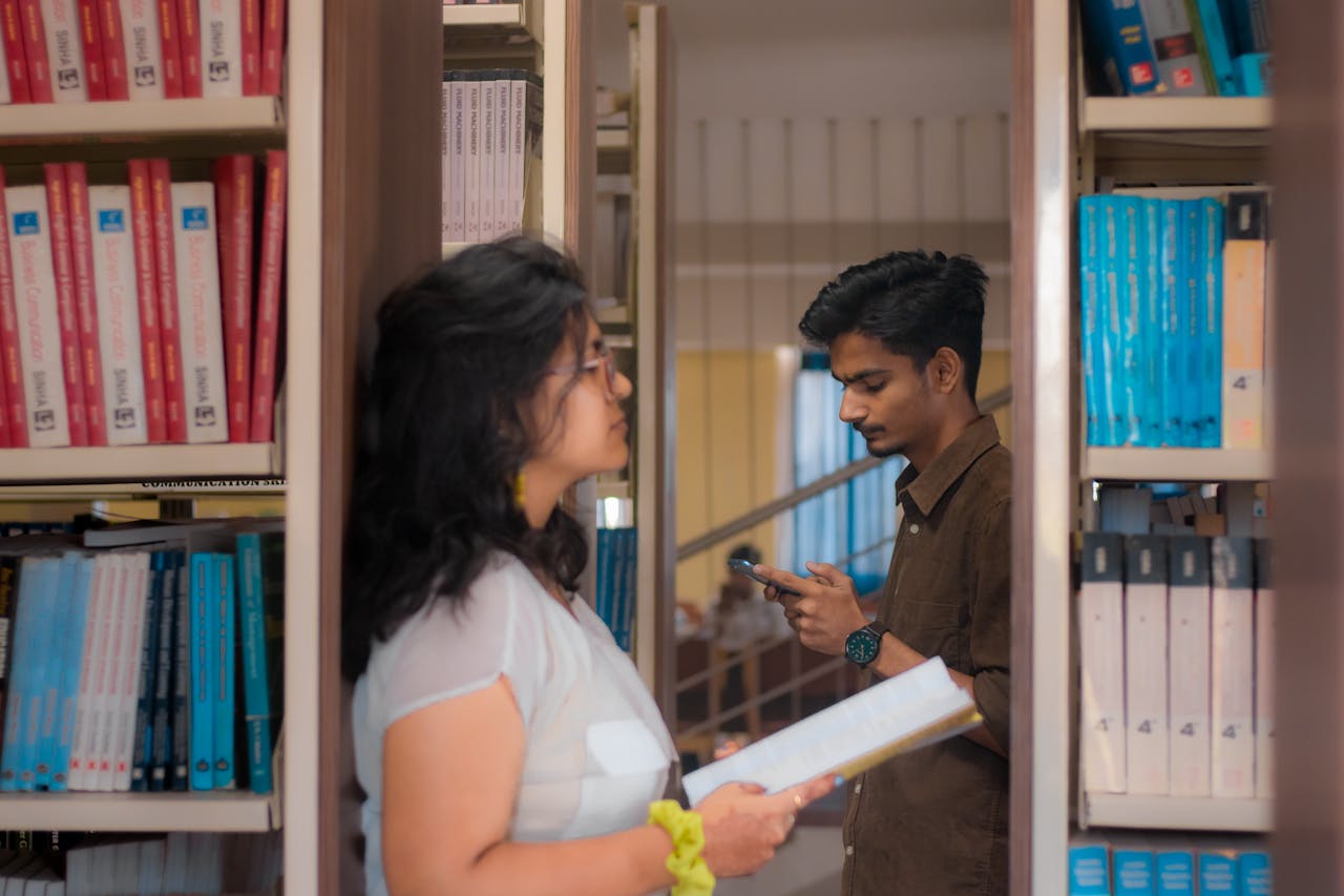 A young man and woman study surrounded by books in a New Delhi library.